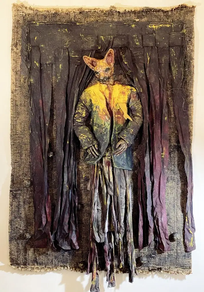 photo of catman sculptor installed on old rug